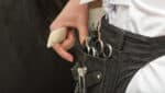 Close-up of a hairdresser's tool belt containing high-quality hairdressing scissors and comb, highlighting professional equipment for precise hairstyling.